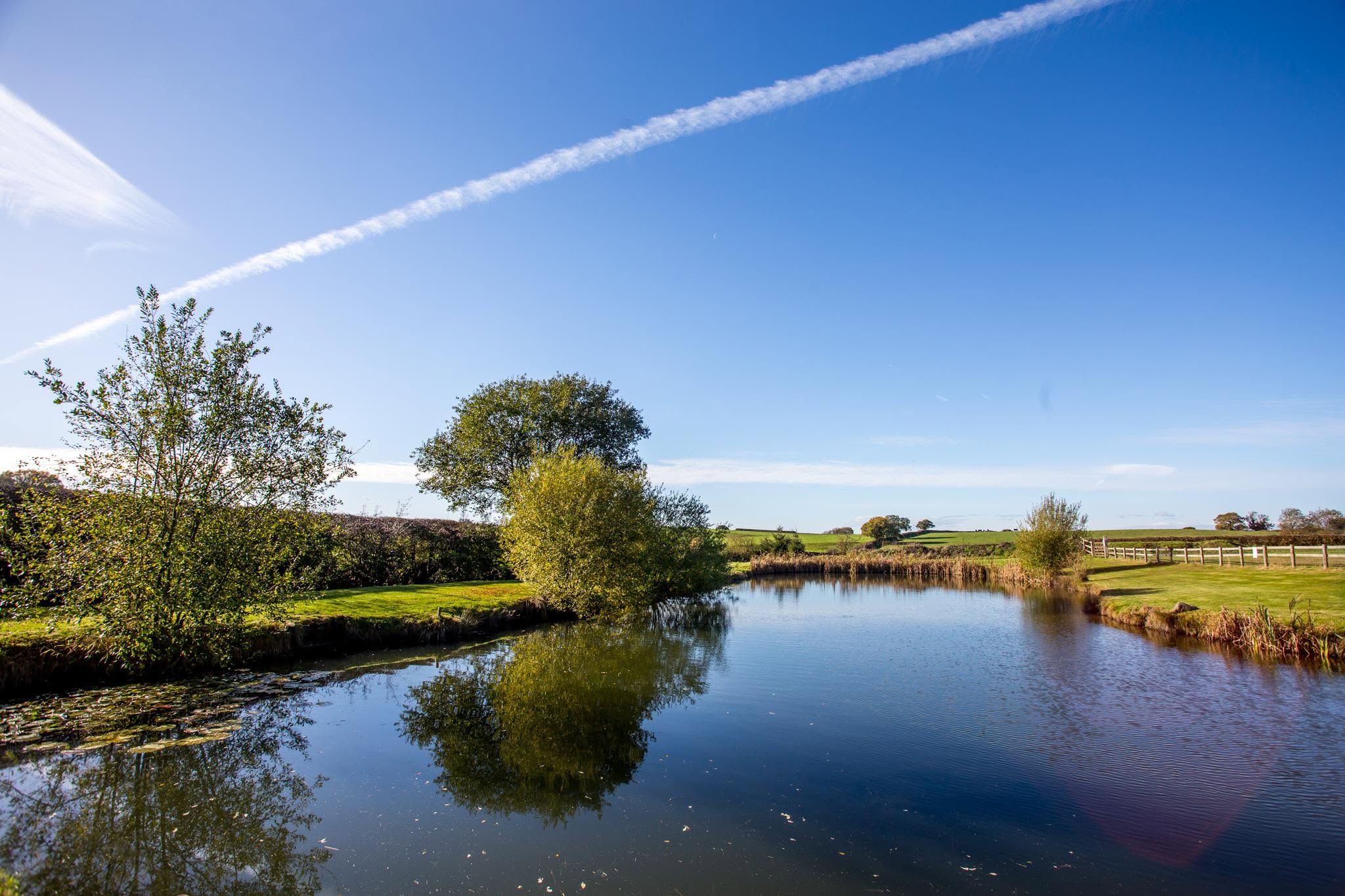 The fishing lake at The Lodge, calm water and blue sky